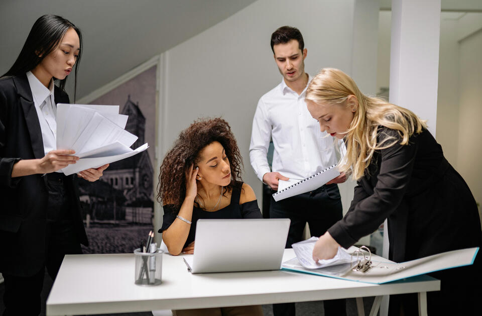 Photo by Yan Krukau A stressed team leader managing workplace burnout, sitting at a conference table in conversation with colleagues. Therapy for professionals and leaders at Solstice Transitions Psychology Services—serving Florida and Kansas.